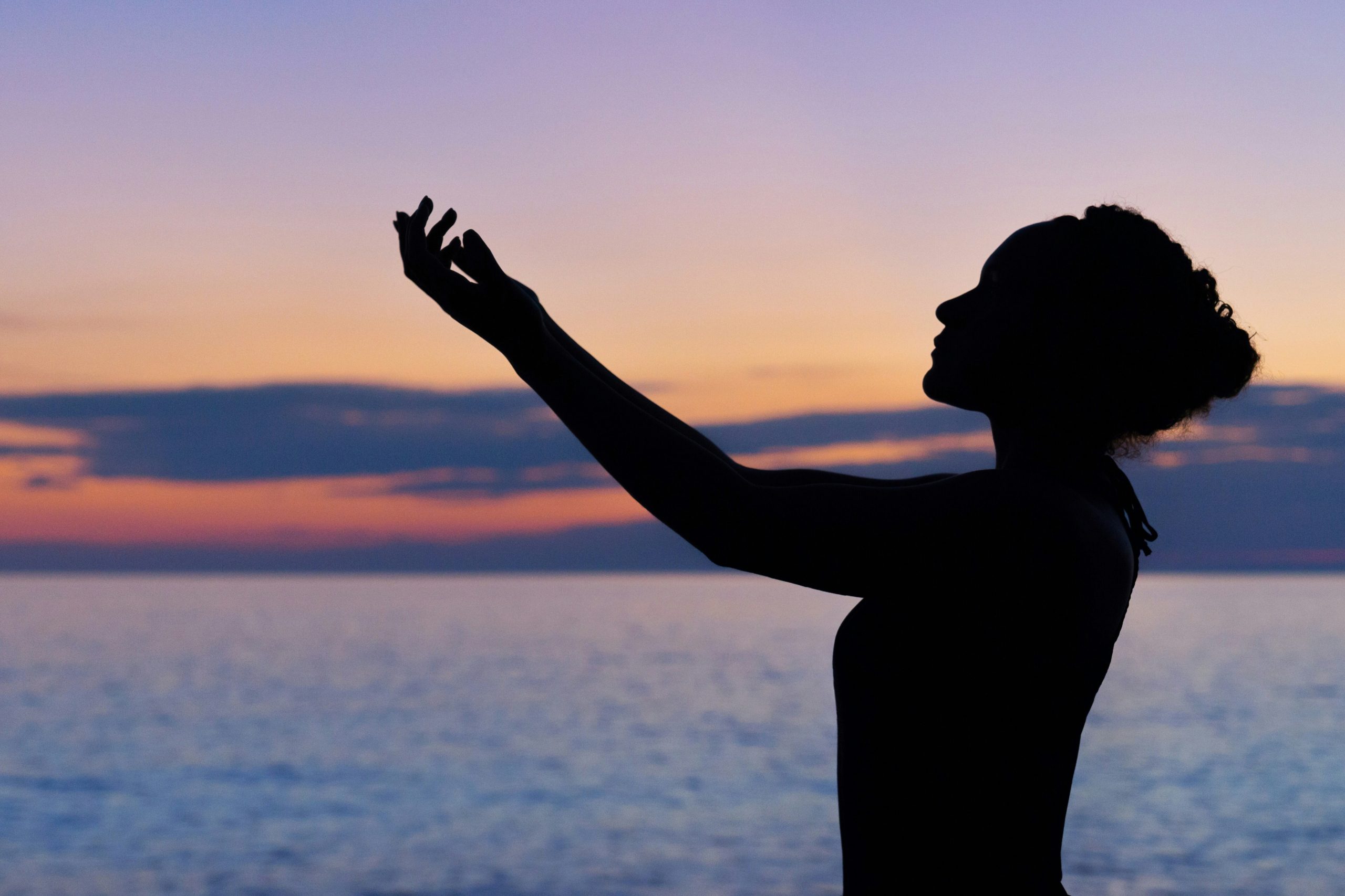A woman doing yoga at sunset