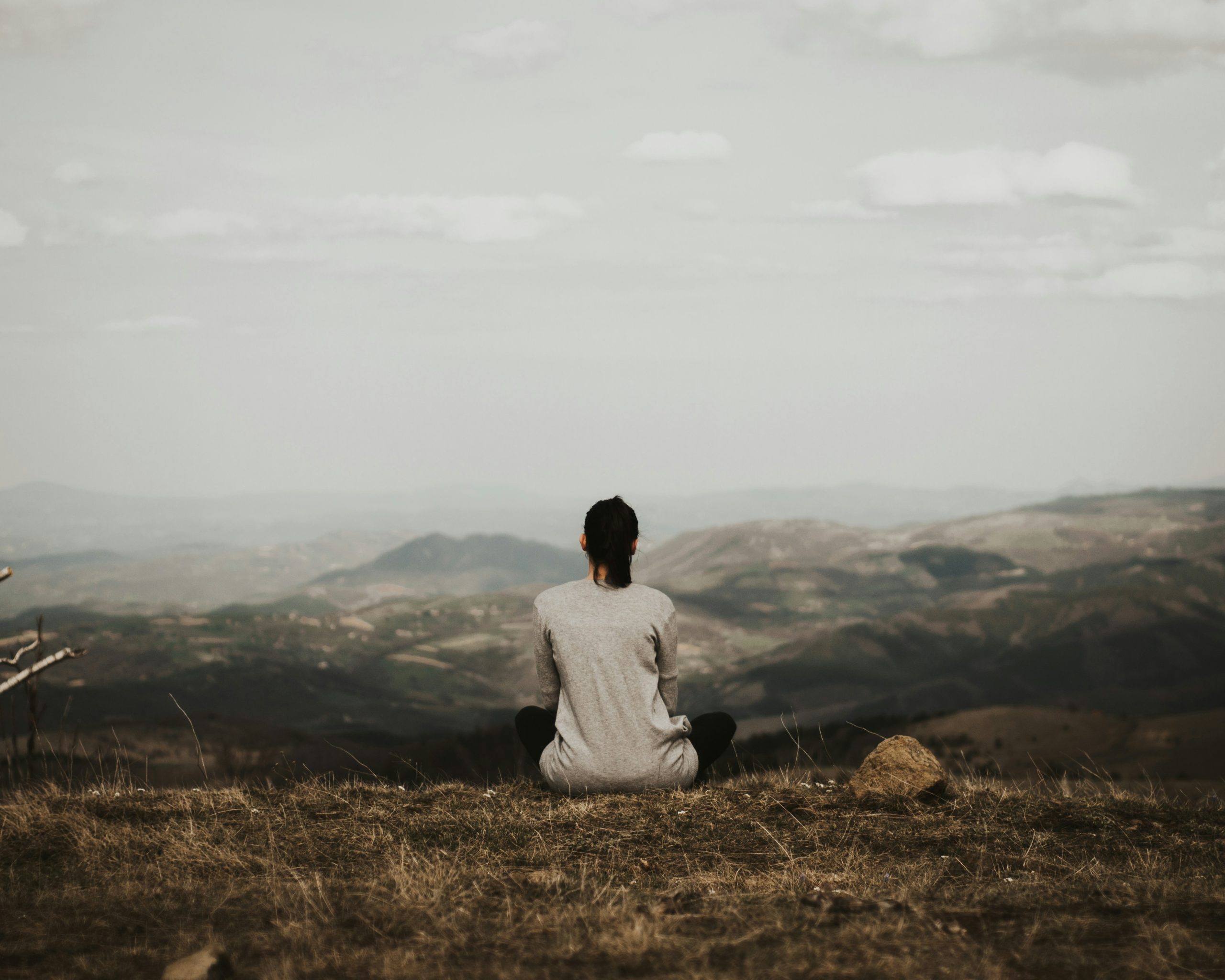 A woman sitting in a clearing meditating.