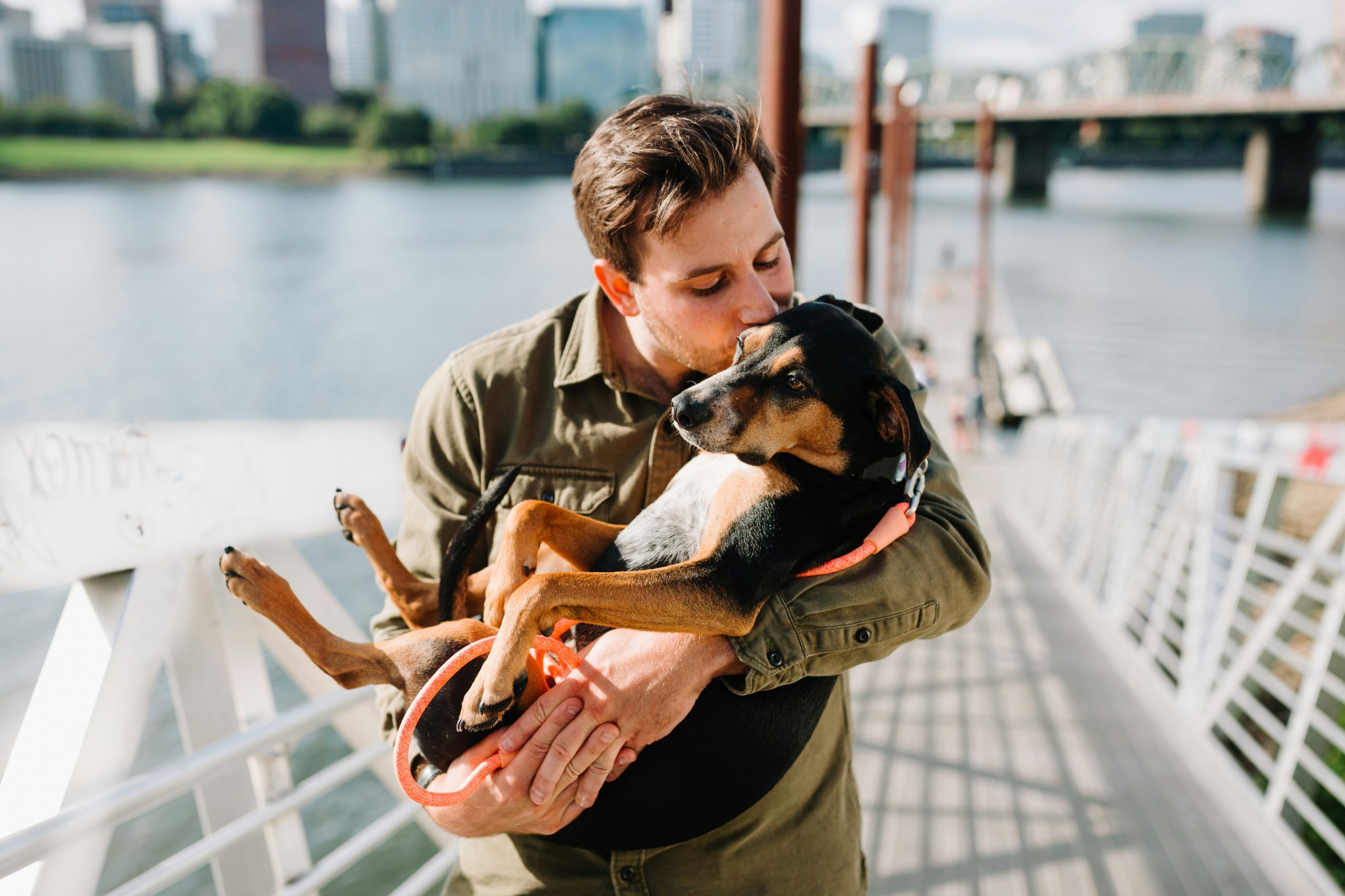 A man holding his dog and kissing his head.